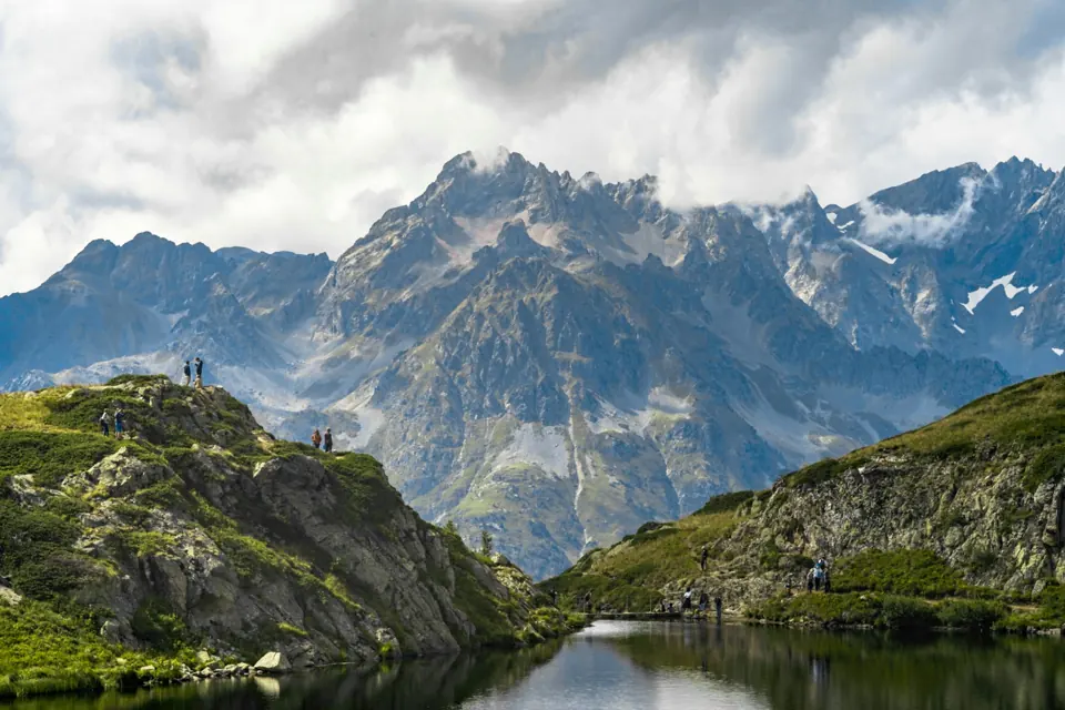 Personnes devant un lac et un panorama de montagne à Alpe d’Huez