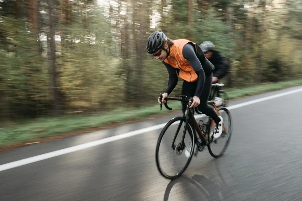 Cycliste casqué sur un vélo de route dans une forêt