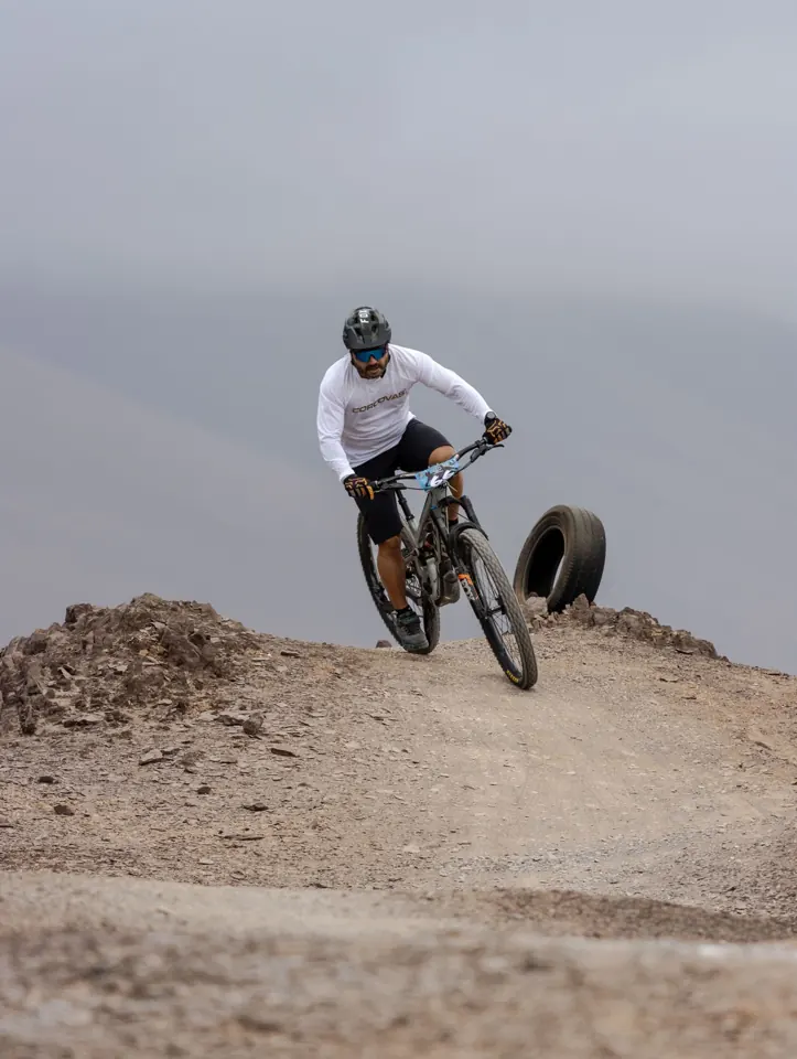 Cycliste casqué sur un VTT dans un sentier rocheux